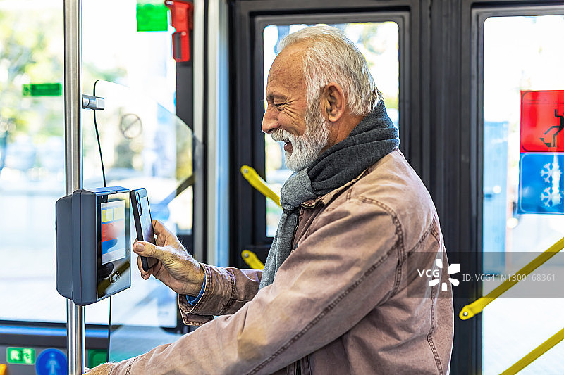 年长商人用手机支付交通票图片素材