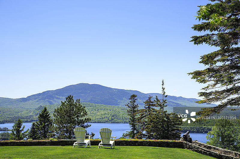 在草坪上眺望穆斯海德湖和山脉的阿迪朗达克椅图片素材
