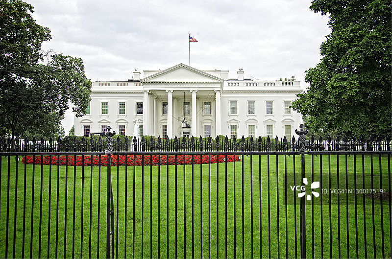 前景是红色花朵的白宫图片素材