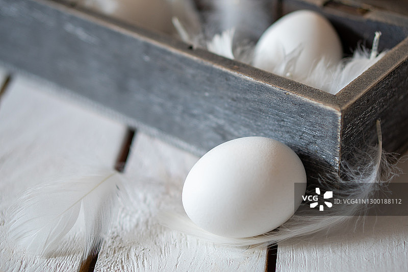 白色鸡蛋、羽毛和木盒极简复活节装饰图片素材