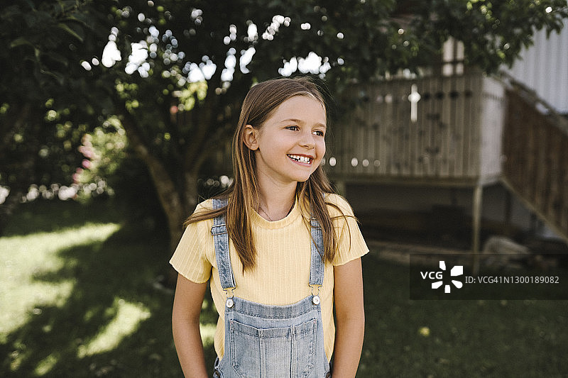 站在后院面带微笑看向远方的女孩图片素材