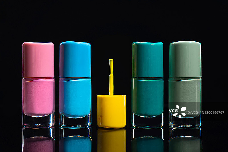 深黑色背景上的流行柔和色指甲油图片素材