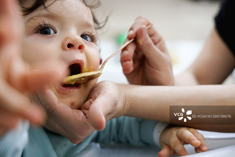 母亲用勺子喂宝宝图片素材