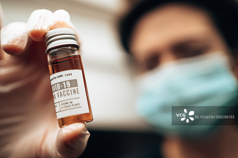 药剂师手持新冠疫苗瓶图片素材