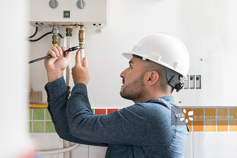 修理工在房屋内安装天然气锅炉图片素材