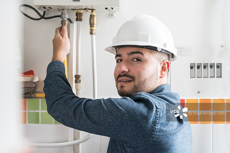 维修人员检查房屋内的天然气锅炉图片素材