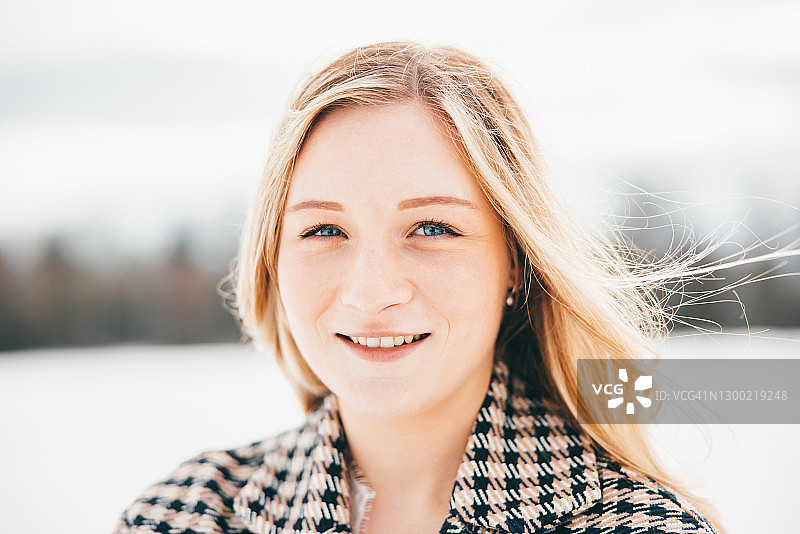 雪地冬季户外快乐微笑的金发女人像图片素材