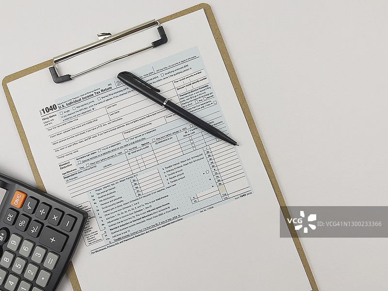 办公桌上印制的税务表格，配有计算器和笔图片素材