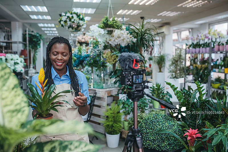 年轻女人在温室里拍摄视频博客图片素材