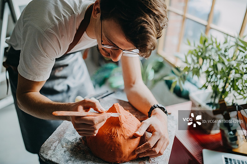 男人在给他的陶器上色图片素材