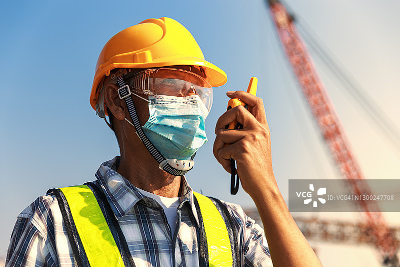 工程师在建筑工地或造船厂使用对讲机进行通讯图片素材