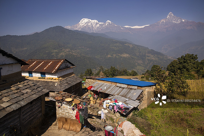 尼泊尔传统村庄房屋，可欣赏安纳普尔纳喜马拉雅山脉的壮丽景色，包括鱼尾峰、安纳普尔纳峰南峰和休恩丘利峰图片素材