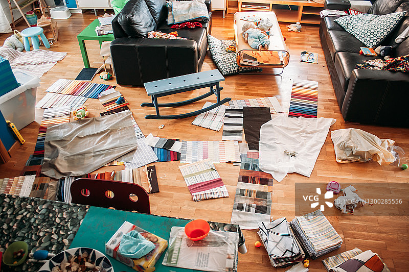 堆满织物样品和玩具的凌乱客厅图片素材
