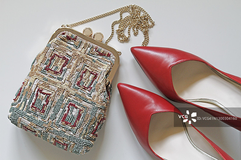 红色细高跟鞋与手拿包平铺展示图片素材