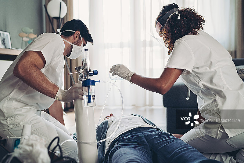 医生对躺在地板上无助的妇女进行急救图片素材