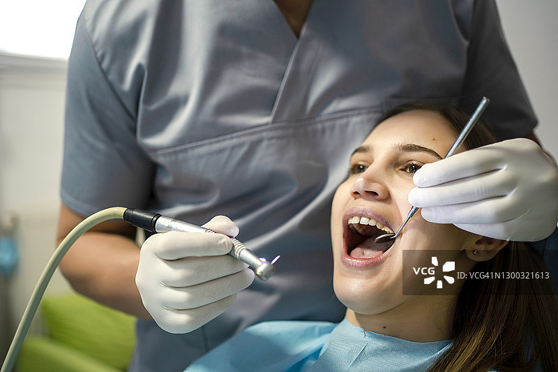 牙科诊所里的牙医和年轻女患者图片素材
