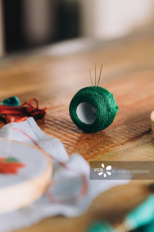 木桌上用于刺绣的绿色线卷图片素材