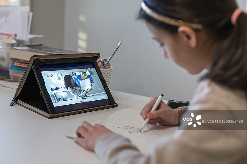 混血女孩用平板电脑与老师进行视频会议图片素材