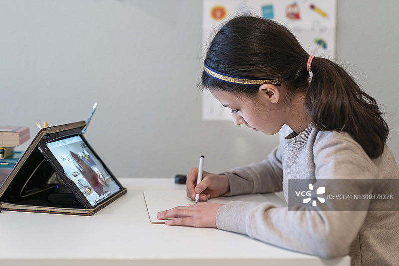 混血女孩用平板电脑与老师进行视频会议图片素材