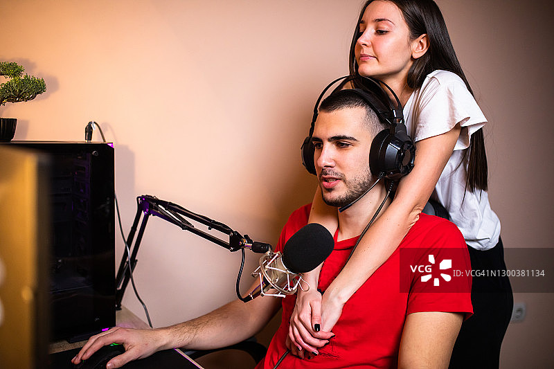 一位年轻女子在男友玩网络游戏时感到无聊图片素材