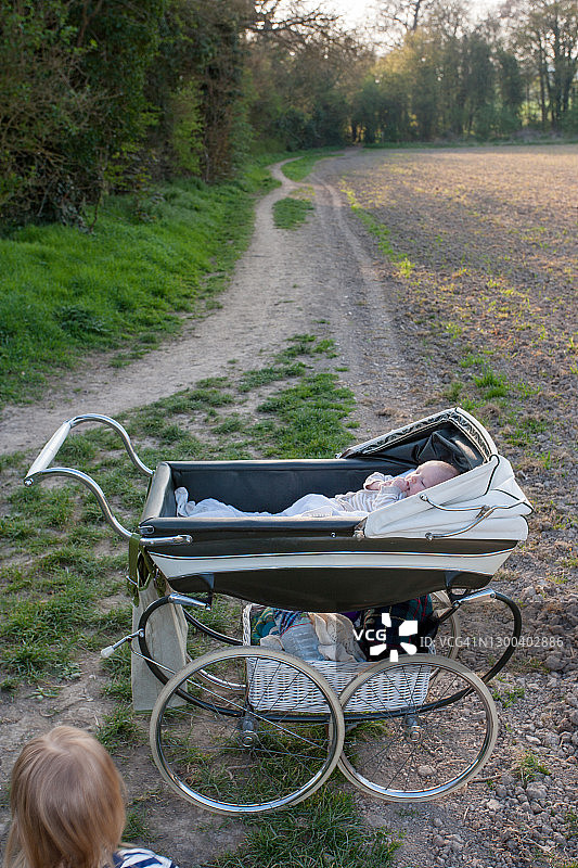 在乡间小路上与两个男孩和婴儿车散步图片素材