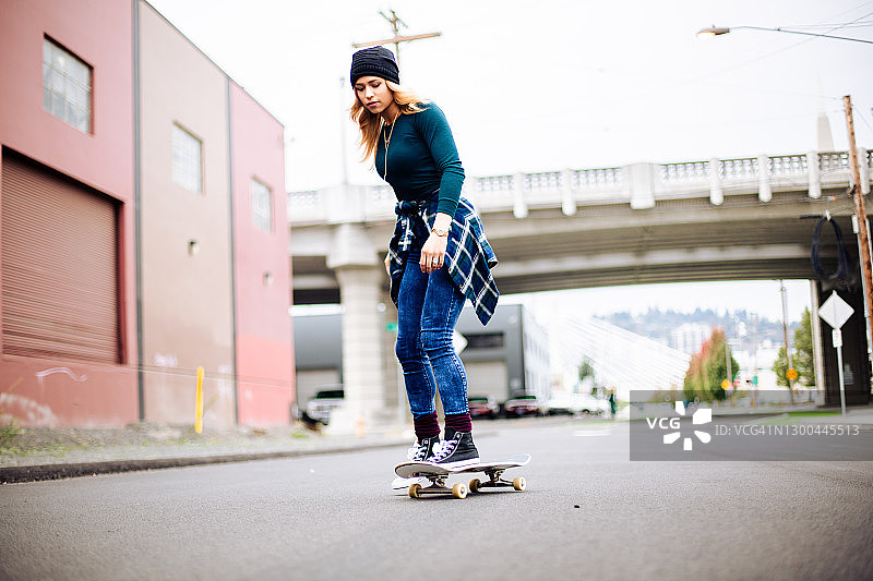 年轻女子在街上玩滑板图片素材