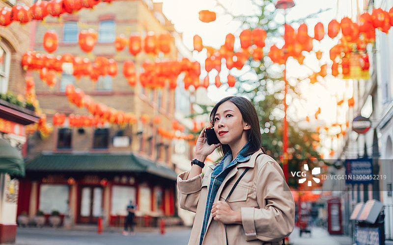 中国春节期间在唐人街用手机交谈的年轻女人图片素材