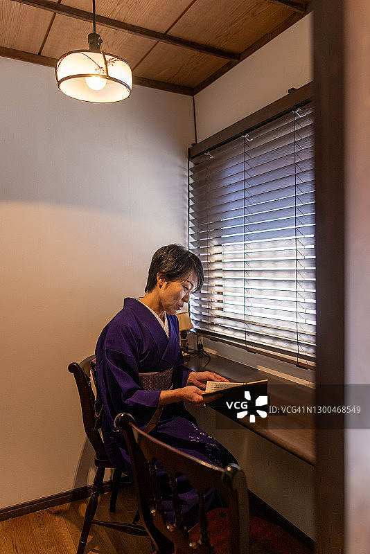 身穿和服的日本女人在老房子里读书图片素材