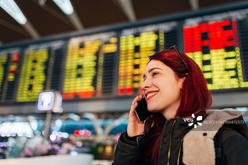 独自旅行的女性在上海浦东机场航站楼着陆后用手机叫优步图片素材