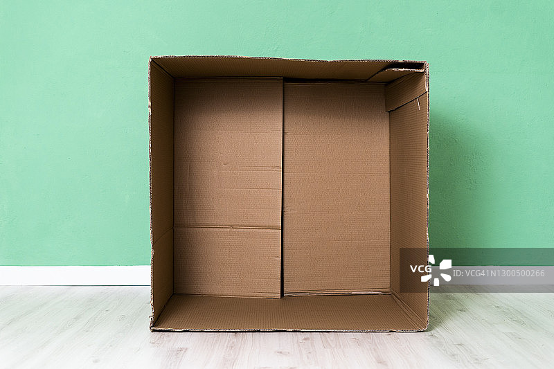 公寓内靠绿色墙壁的空纸板箱图片素材