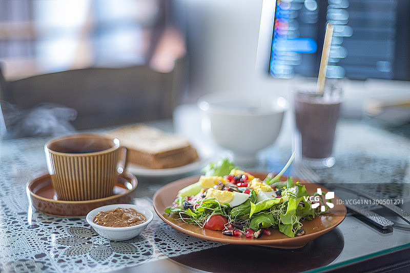 晨间健康食品：沙拉、奶昔、烤面包与平板电脑图片素材