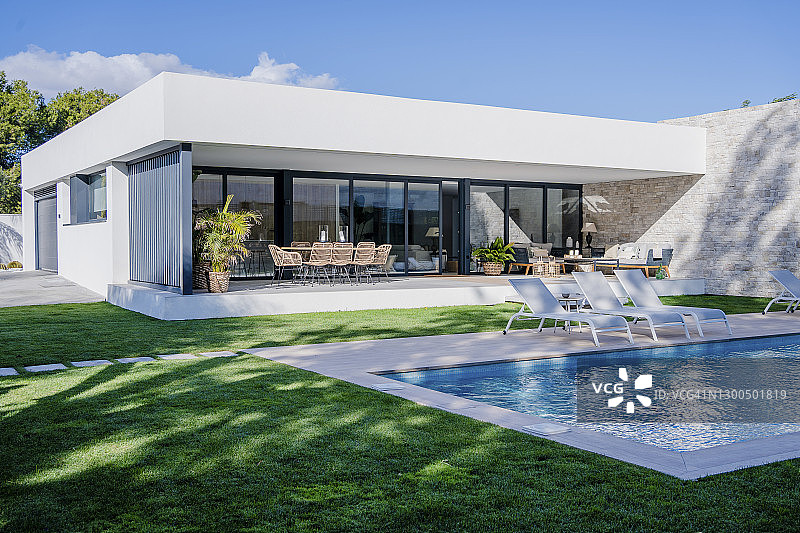 现代住宅泳池边的空旷躺椅图片素材