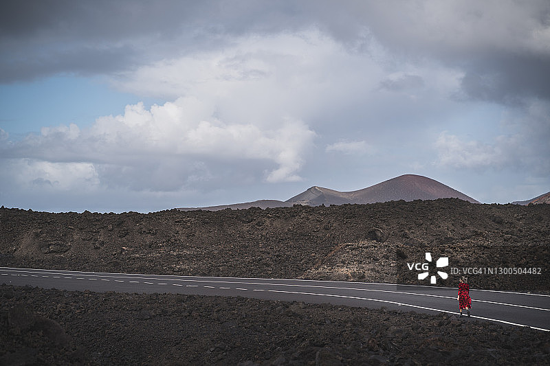年轻女人走在西班牙兰萨罗特岛的道路上图片素材