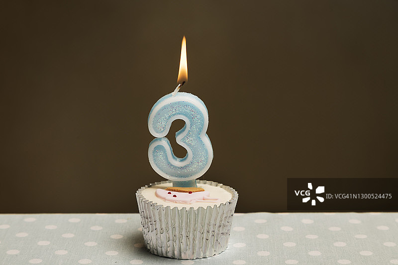 燃烧数字3蜡烛的纸杯蛋糕图片素材
