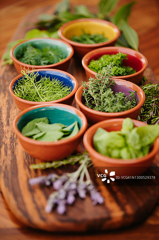 乡村木板上碗中的七种草药，焦点集中在茴香图片素材