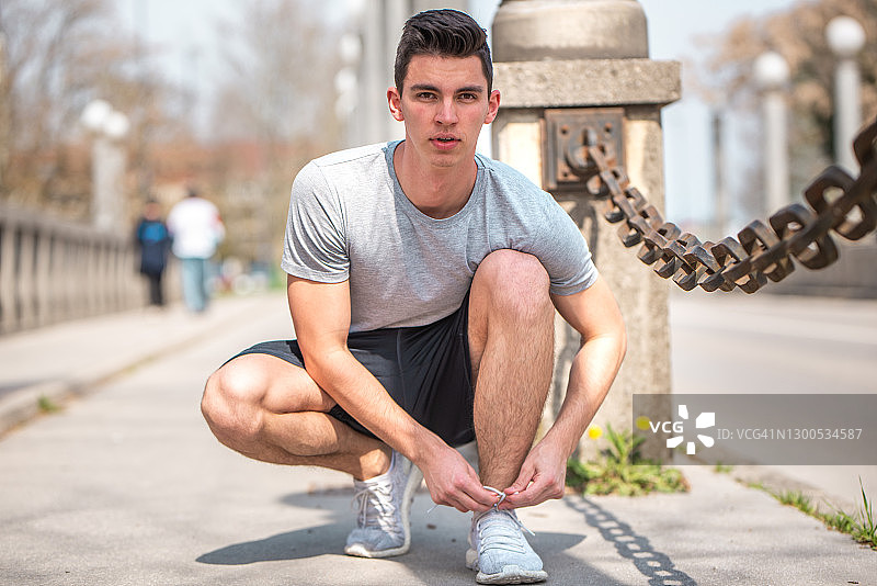 系运动鞋带的年轻男子图片素材