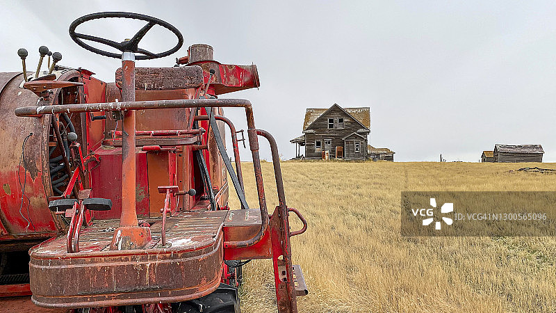 废弃农场上的老式联合收割机图片素材