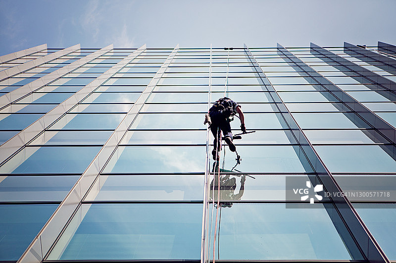 清洁工正在清洗办公楼外墙的窗户图片素材