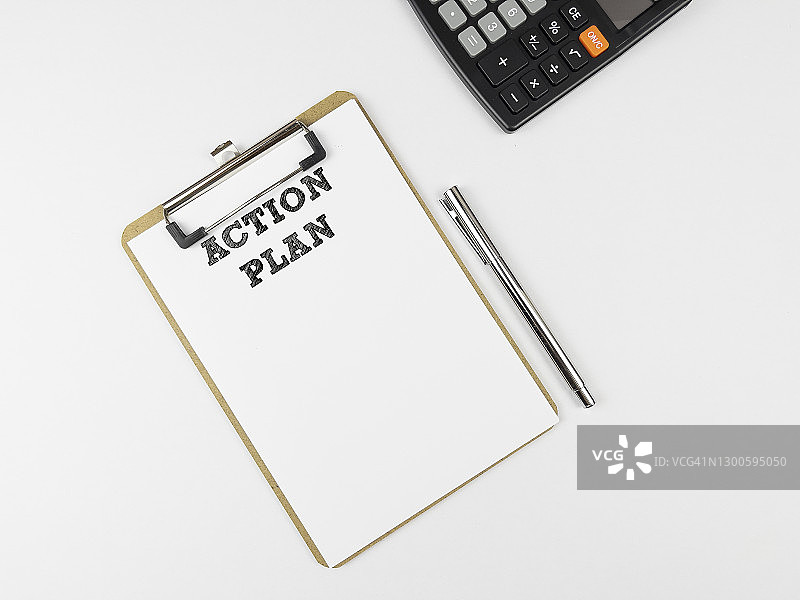 记事本上的“行动计划”文字，附笔和计算器。马来西亚，新年决心，2021年，愿望，财务，动机，计划概念，白色背景。图片素材