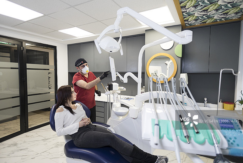 男牙医在牙科诊所检查病人图片素材