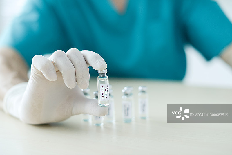 医生拿着一瓶新冠疫苗图片素材