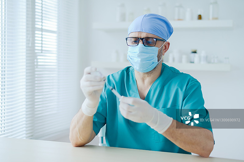 医生拿着一瓶Covid-19疫苗图片素材