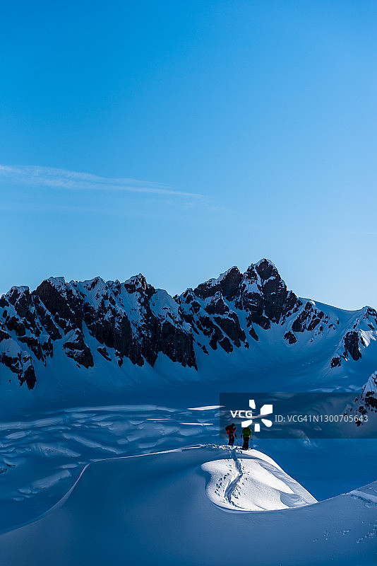 清晨，滑雪者准备从山坡滑下图片素材