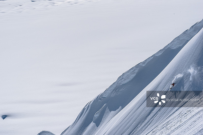 在山间雪坡上滑雪的滑雪者图片素材