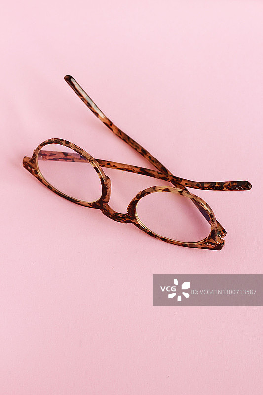 俯视粉色背景上的眼镜图片素材