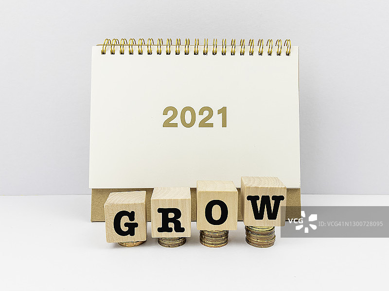 积木玩具堆叠硬币与2021年日历，商业金融设计概念。领导力，发展，积木形状，白色背景图片素材