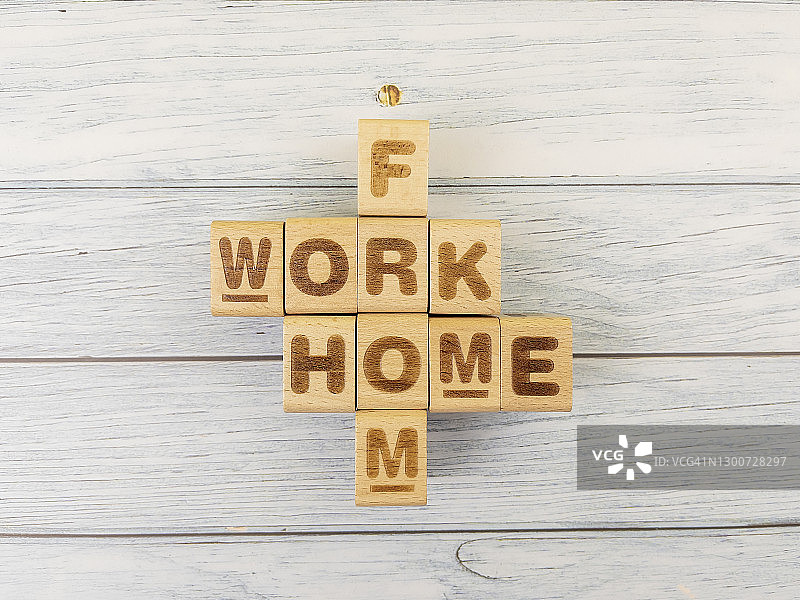 带有居家办公文字的立方体木块玩具，用于商业设计概念和活动。领导力，发展，方块形状，积木活动。木制背景。图片素材