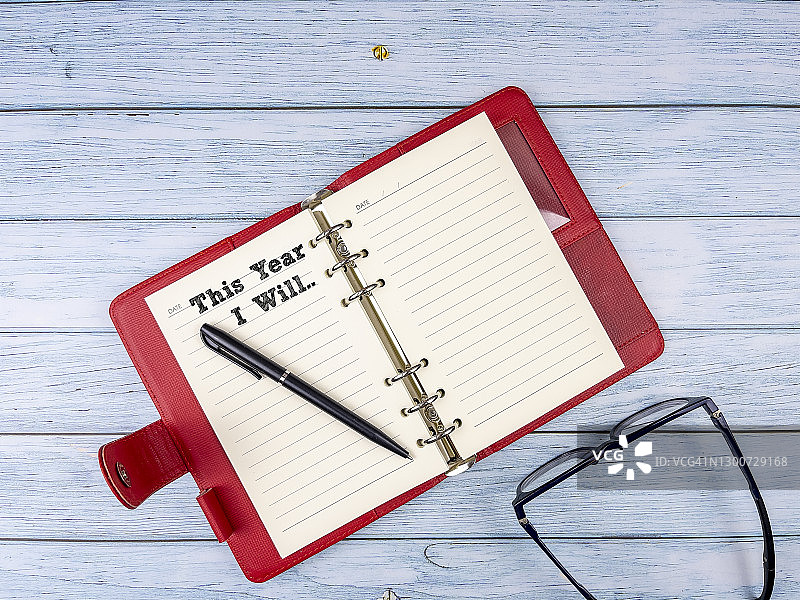 今年我会——红色日记本、眼镜和钢笔，新年概念背景图片素材