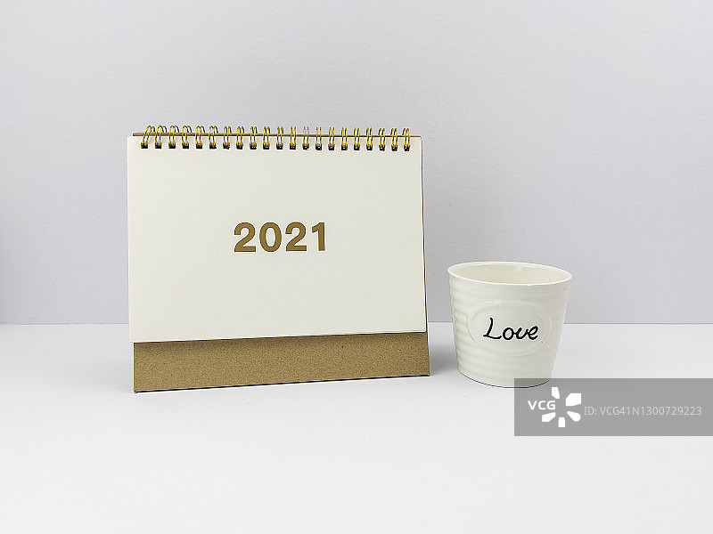 2021新年日历：白色马克杯上的爱心文字，木桌背景图片素材
