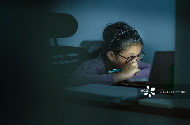 疲惫的亚洲中国学生在深夜学习图片素材